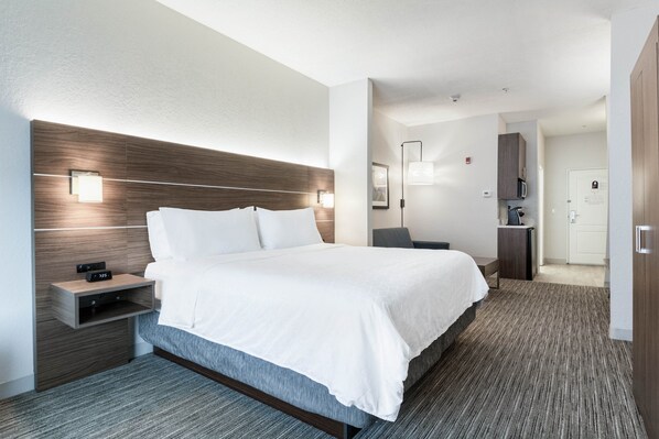Et moderne hotelværelse med en stor seng, sengeborde, et skrivebord og en mikroovn.