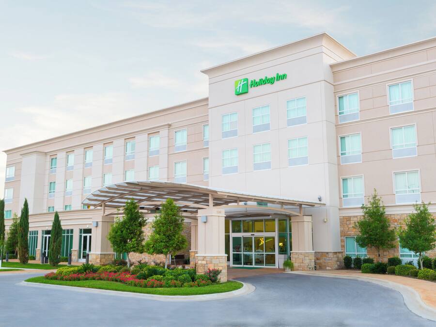 A Holiday Inn hotel with a covered entrance, multiple floors, and a landscaped driveway.