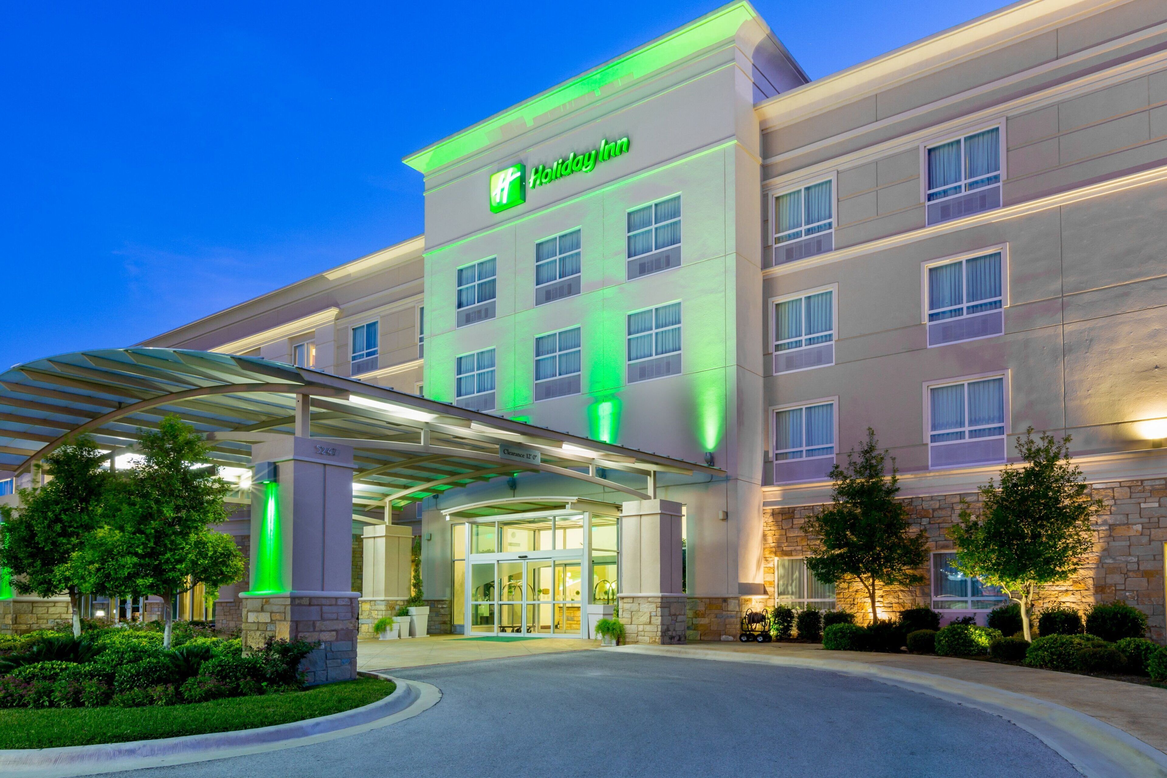 Un hotel Holiday Inn con entrada cubierta, varios pisos y fachada de piedra.