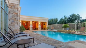Relax by the pool surrounded by a stone deck and lounge chairs.