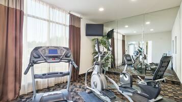 A gym with treadmills, elliptical machines, and a stationary bike.