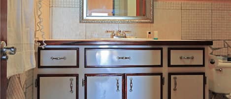 A bathroom with a vintage-style vanity, a large mirror, and a toilet.