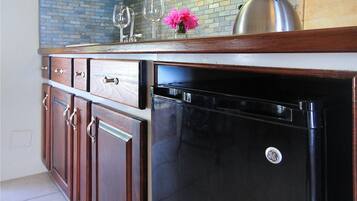 A kitchen with wooden cabinets, a black dishwasher, and a brick backsplash.