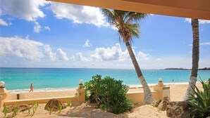 A beach view with palm trees, a sandy area, and a clear blue sky. - Mary's Boon Beach Resort & Spa (Simpson Bay)