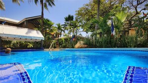 A swimming pool with tiled edges, surrounded by tropical vegetation and a building labeled "Departure Lounge". - Mary's Boon Beach Resort & Spa (Simpson Bay)