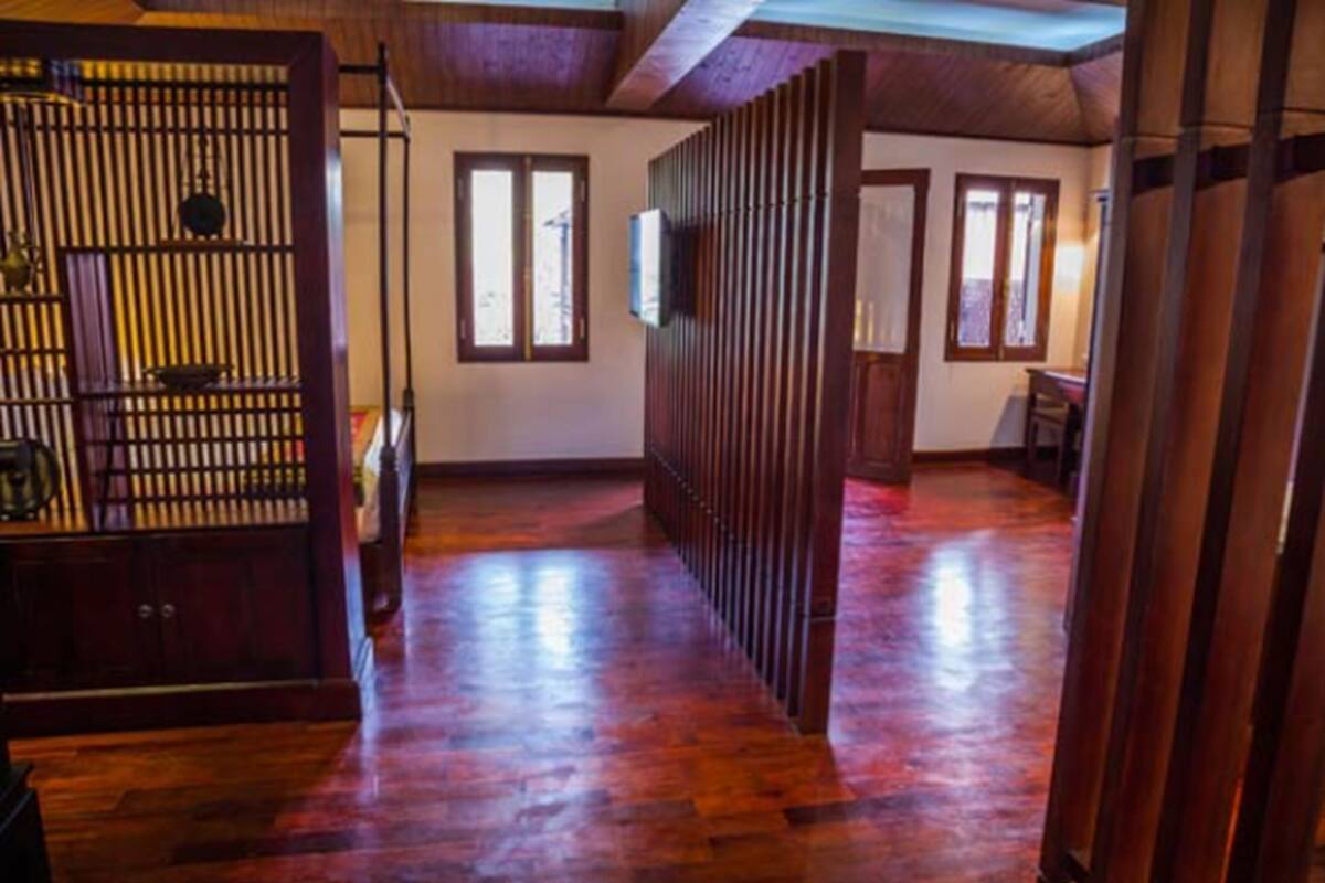 A spacious room with wooden flooring, a sliding door, and a view through a window.