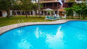 A swimming pool with lounge chairs and a building in the background.