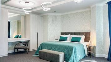 A hotel room with a large bed, a desk, a chair, and a mirror.