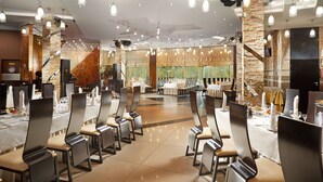 A spacious dining area with high ceilings, modern pendant lighting, and a mix of brick and stone walls. - Hotel Victoria Minsk (Minsk)