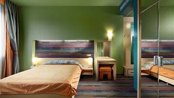Quarto de hotel com duas camas, uma escrivaninha, um espelho e um banquinho.