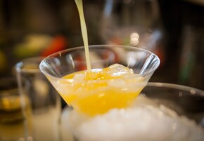Cocktail-juomaa kaadetaan martini-lasiin.