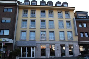 A multi-story hotel with a yellow facade, multiple balconies, and a classic hotel sign. - Classic Hotel Kaarst (Kaarst)