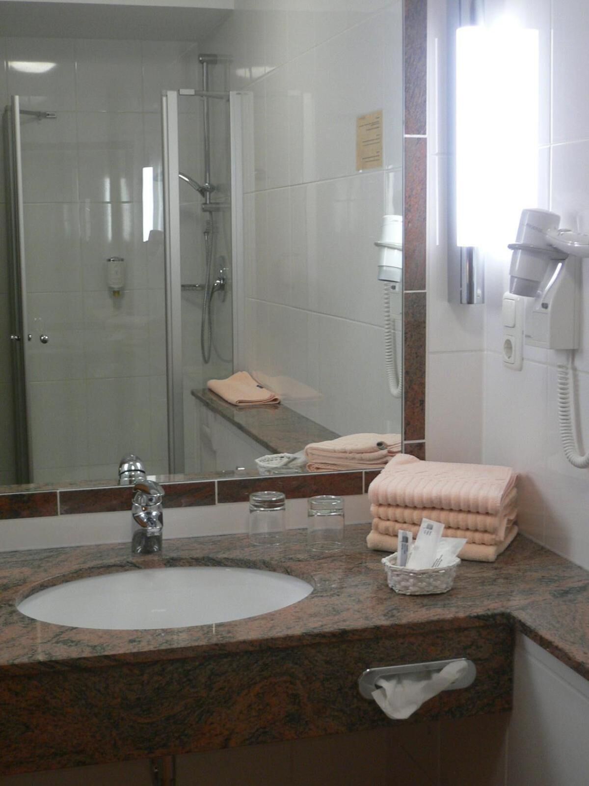 shower, hair dryer, slippers, towels