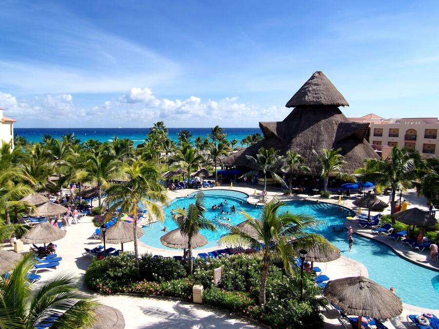 Una piscina al aire libre, sombrillas, sillones reclinables de piscina