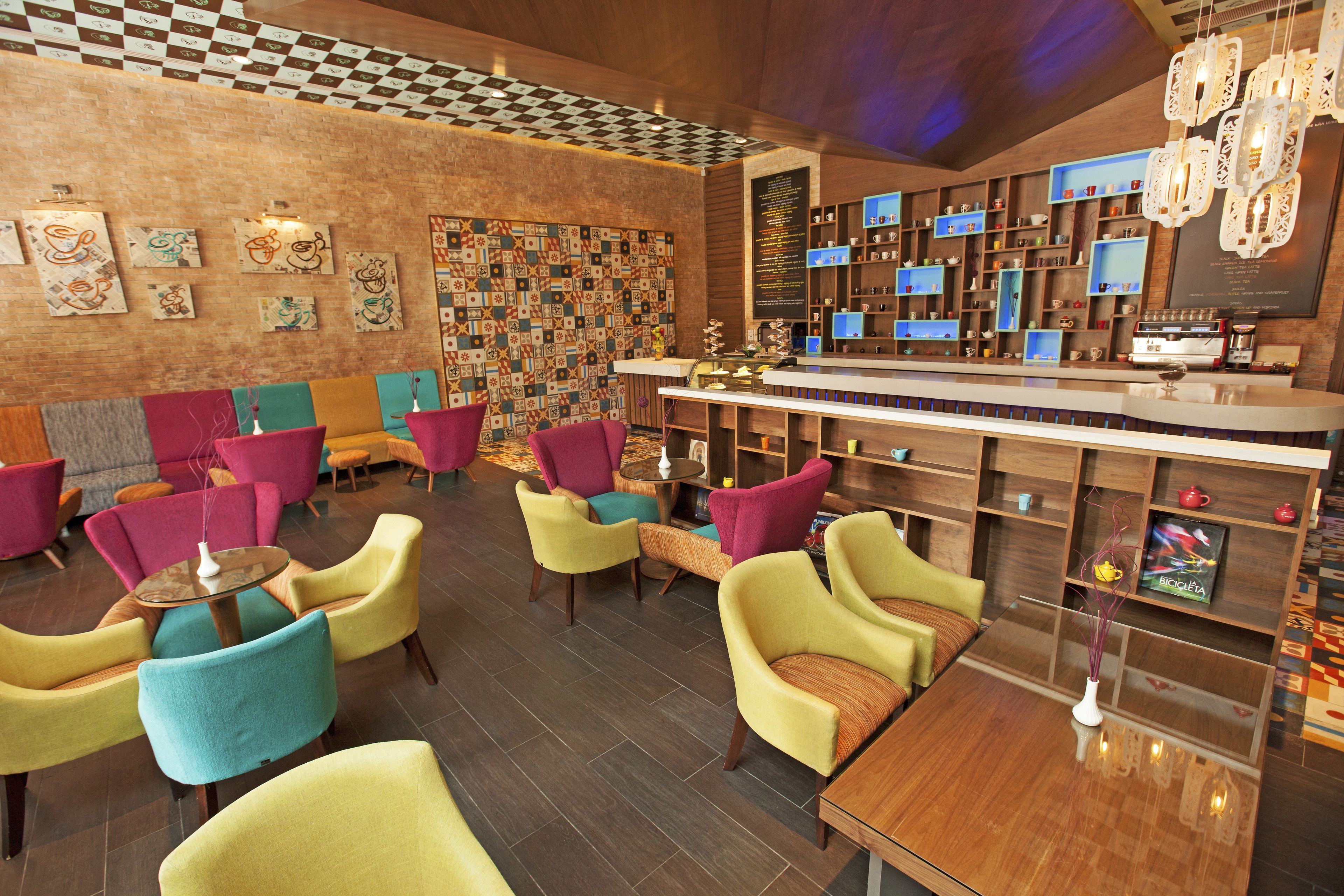 A modern bar area with colorful chairs and a wooden bar counter.