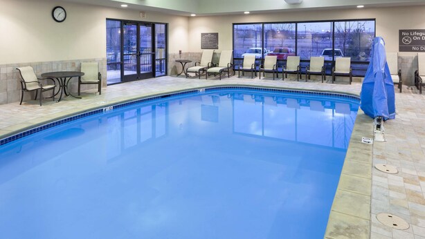 An indoor swimming pool with lounge chairs and a clock on the wall. - Hampton Inn & Suites Colorado Springs/I-25 South (Colorado Springs)