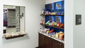 A hotel corridor with a snack bar stocked with various snacks and a mirror reflecting the room. - Hampton Inn & Suites Colorado Springs/I-25 South (Colorado Springs)