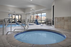 A pool area with a hot tub, a lounge chair, and a table with chairs. - Hampton Inn & Suites Colorado Springs/I-25 South (Colorado Springs)