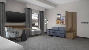 Quarto de hotel com cama, escrivaninha, cadeira, sofá, televisão, janela e aquecedor fixado na parede.