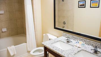 A bathroom with a bathtub, toilet, and sink.