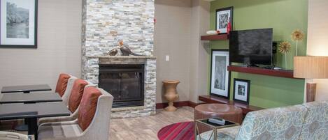 A living room with a fireplace, a television, and a sofa.