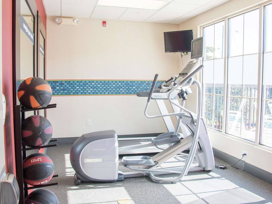 A gym with treadmills, a stationary bike, and a wall-mounted TV.