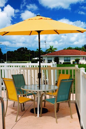 Una piscina al aire libre, sombrillas, sillones reclinables de piscina