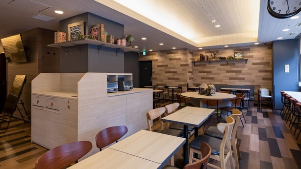 Restaurante moderno com piso de madeira, balcão central e diversas áreas de estar.