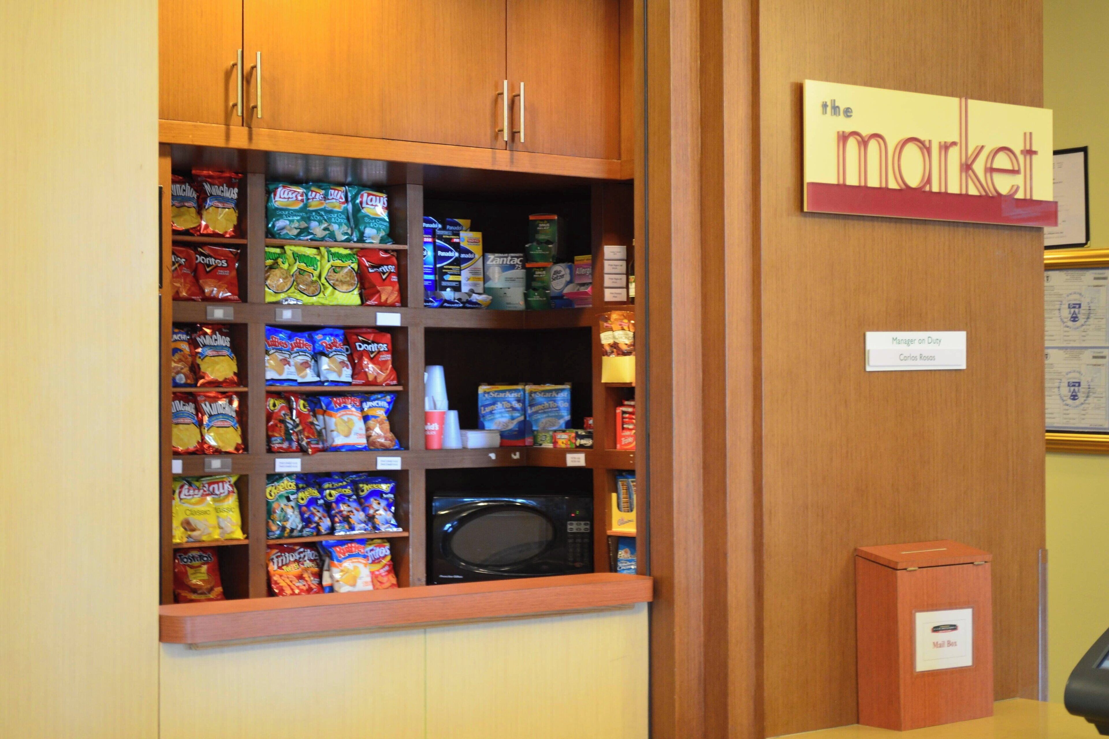 A snack display with various chips and a microwave.