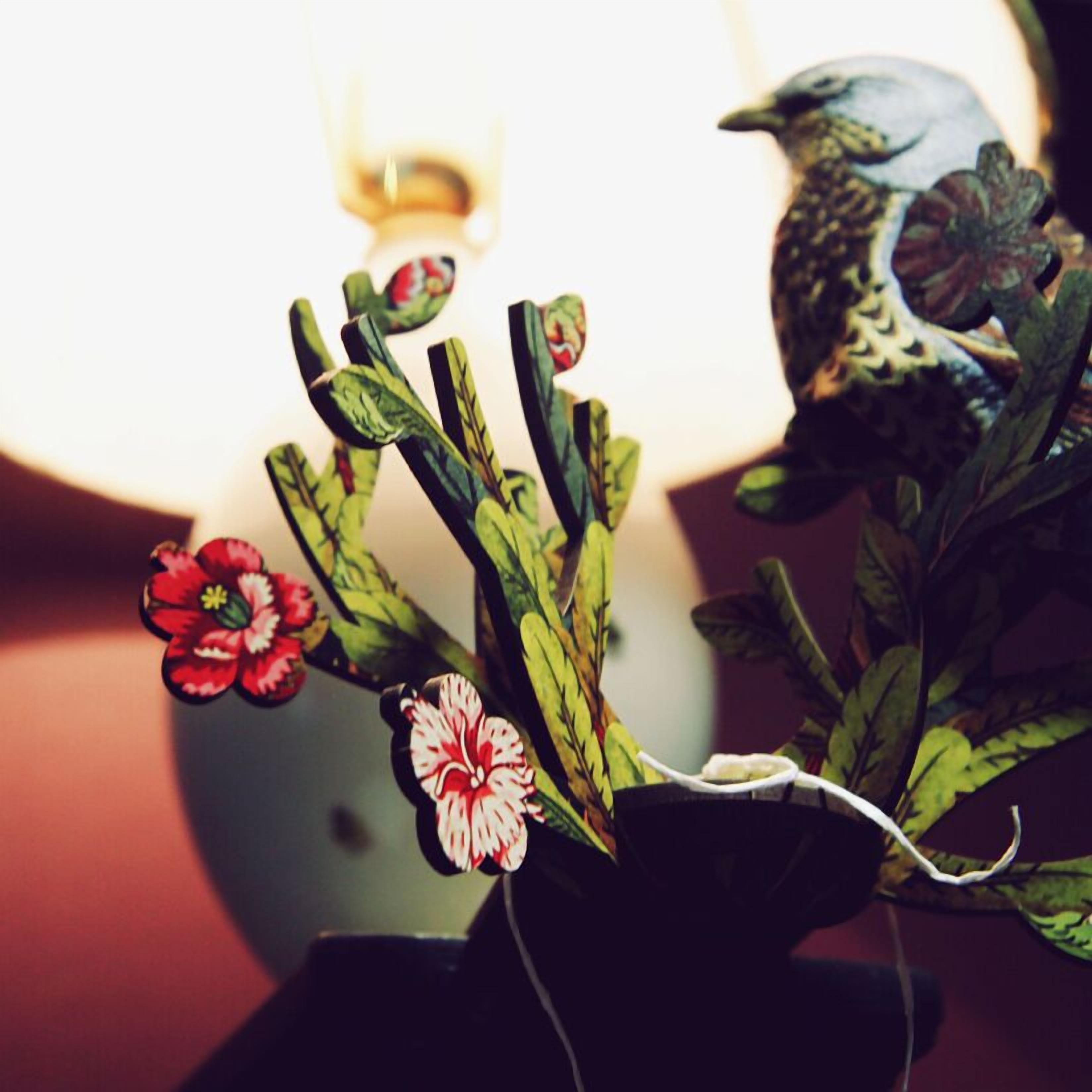 Una planta en maceta con flores rojas y hojas verdes.