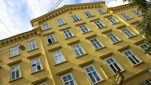 A multi-story yellow building with a row of windows on each floor. - Saint Shermin (Vienna)