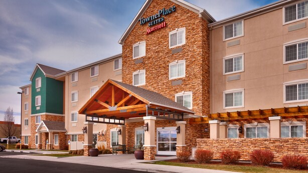 Un hôtel TownePlace Suites Marriott doté d’une façade en pierre, de nombreuses fenêtres et d’un espace d’entrée abrité.