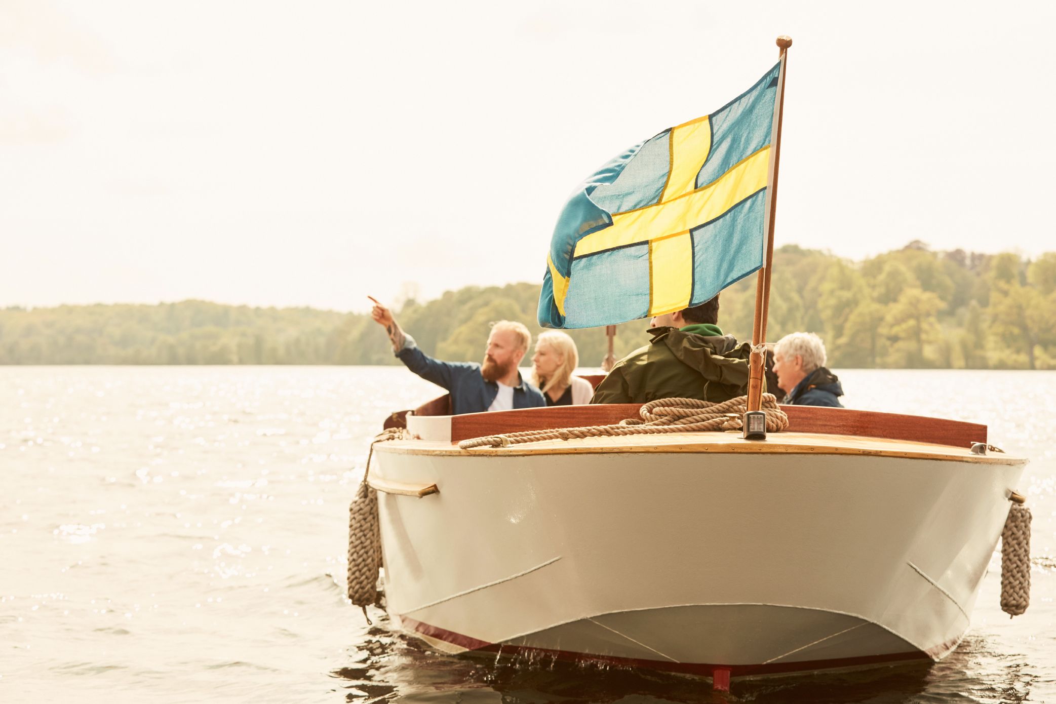 Un barco con bandera sueca, una cuerda y una persona señalando.