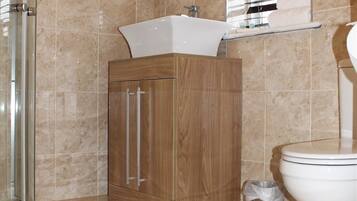 A bathroom with a wooden cabinet, a white sink, and a toilet.
