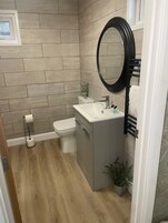 Une salle de bain moderne équipée de toilettes, d’un lavabo et d’un miroir.