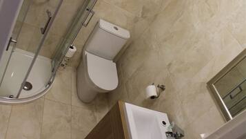 A bathroom with a shower, toilet, and sink.