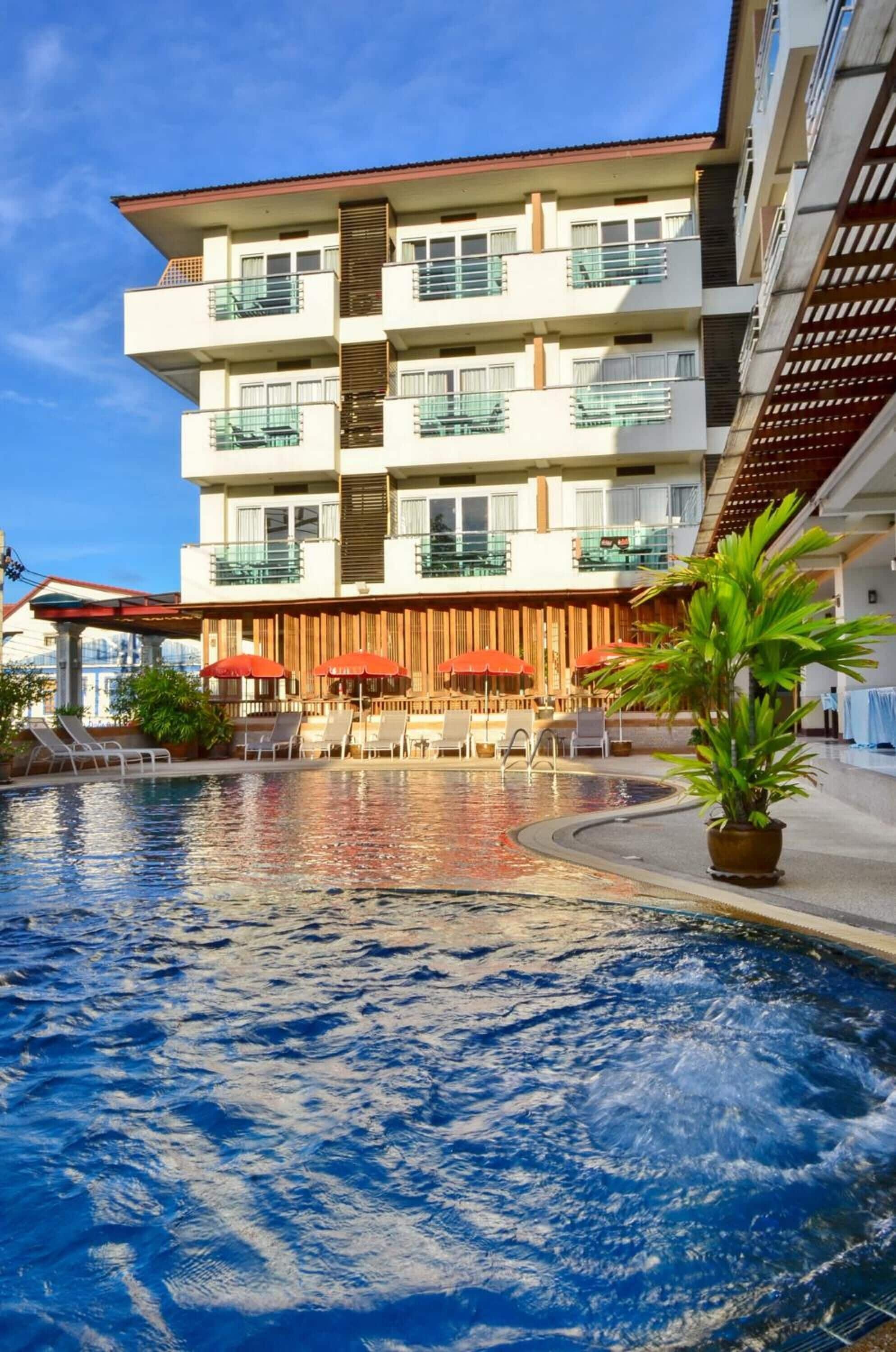 Alberca al aire libre, sombrillas en la alberca y camastros 