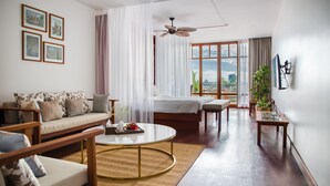 Ein geräumiger Wohnbereich mit Sofa, Couchtisch und einem Bett mit Blick.