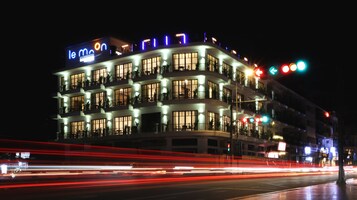 Un hotel de varios pisos con señalización iluminada y balcones.