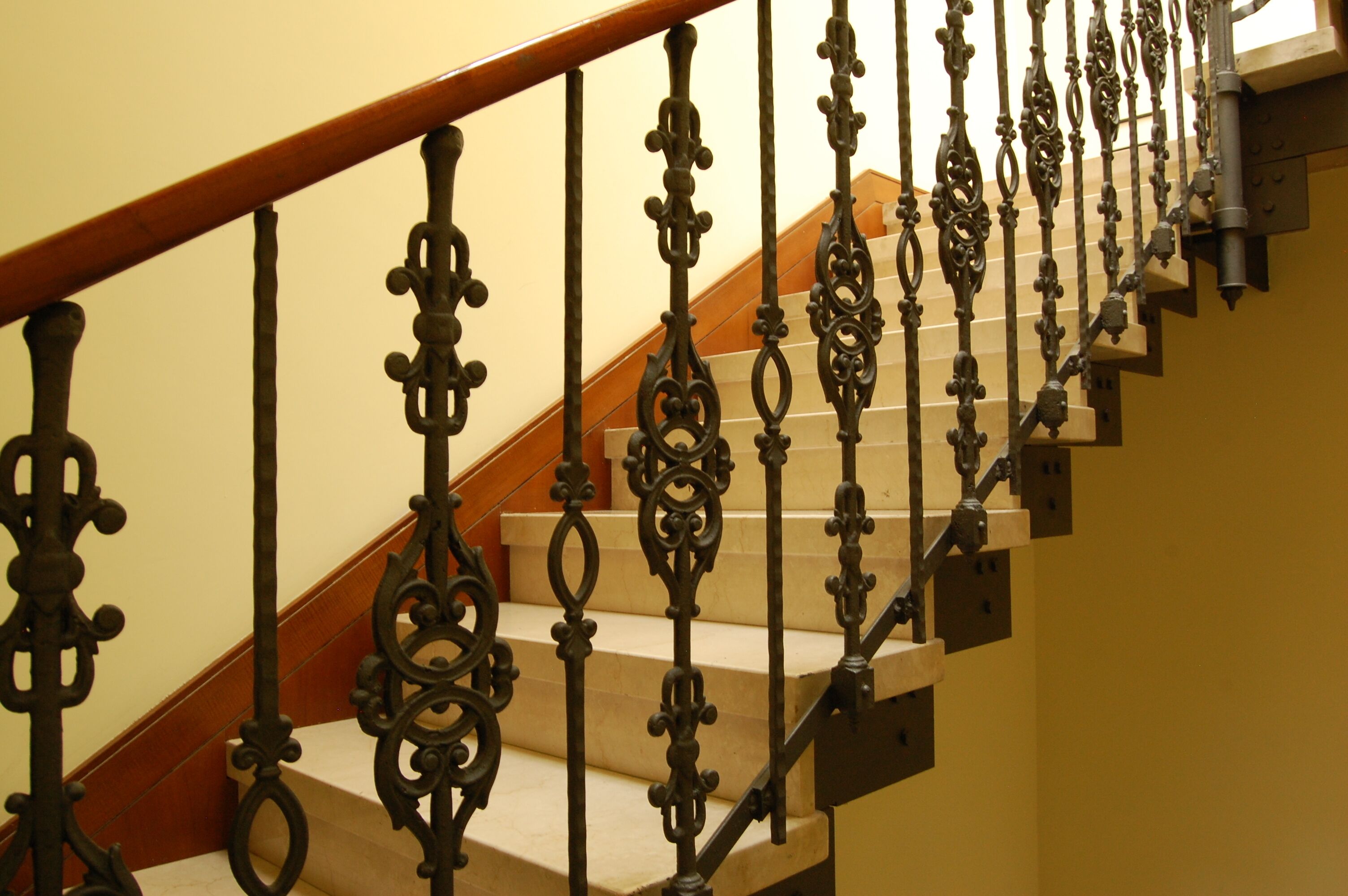 Eine Treppe mit aufwendiger Metallgeländerung und Holzstufen.