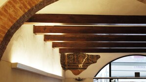 An arched brick ceiling with wooden beams and a decorative carved panel.