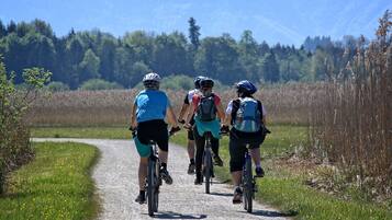 En grupp cyklister på en grusväg, omgiven av grönska och träd.