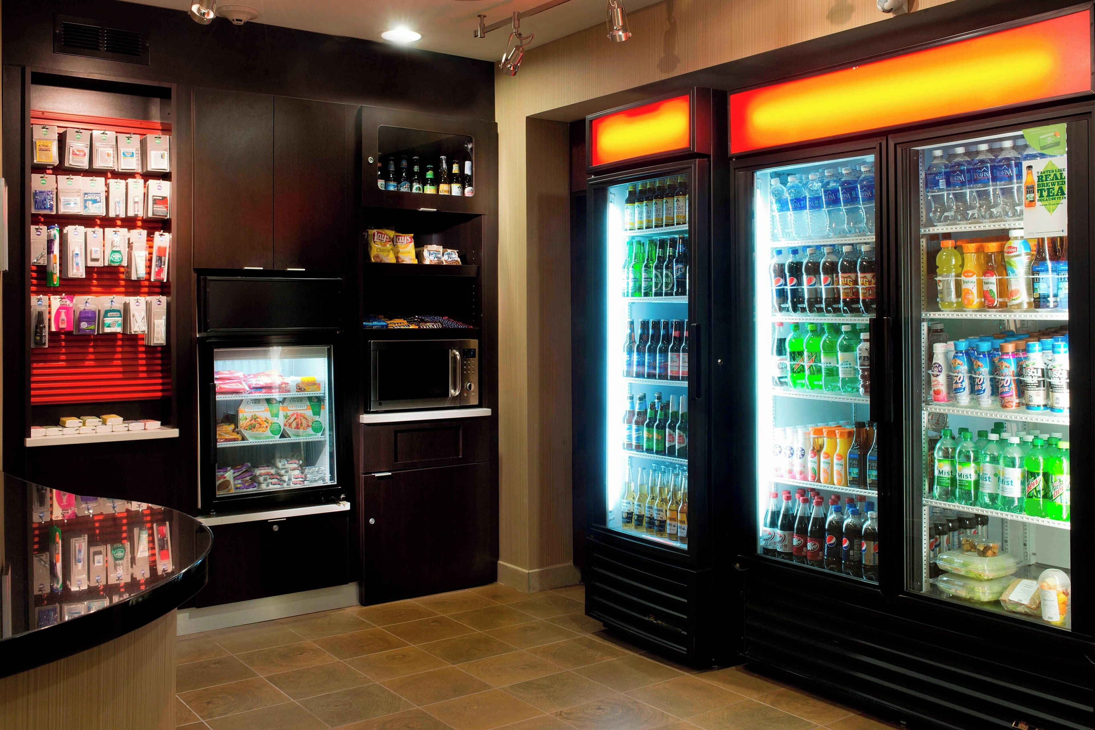 Un espace de vente proposant des distributeurs automatiques de boissons réfrigérées et des présentoirs de snacks.