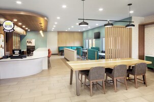 A modern restaurant interior with a counter, seating area, and a dining table.