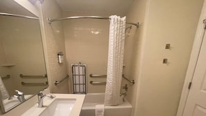 Un baño con lavamanos, espejo y bañera.