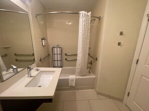 Un baño con lavamanos, espejo y bañera.