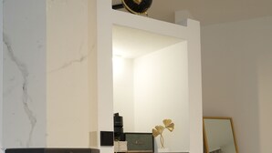 Un salon moderne avec une cheminée, un meuble de rangement noir pour les appareils électroniques et un miroir décoratif.