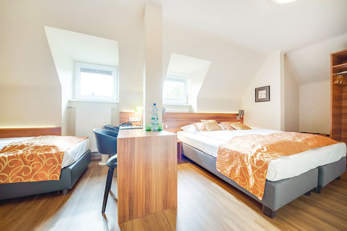 Een hotelkamer met twee bedden, een bureau en een raam.