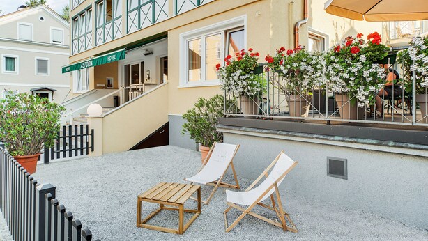 Un hôtel doté d’une terrasse, d’un escalier et de plantes en pot.