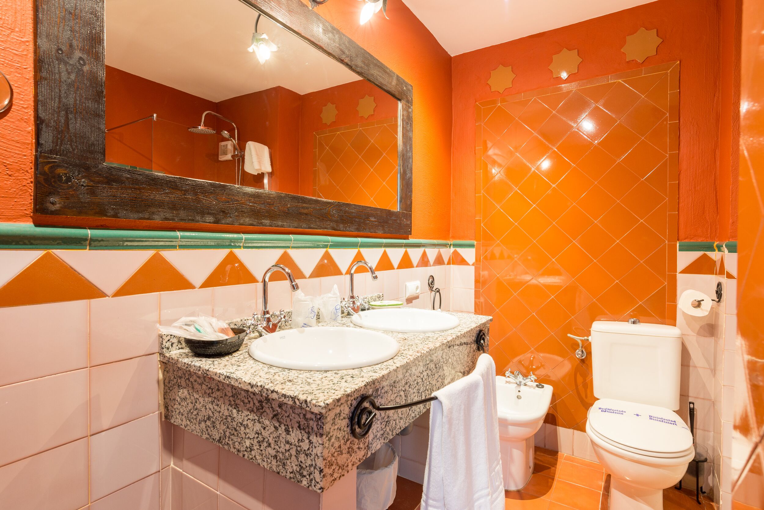A bathroom with two sinks, a toilet, and a shower.